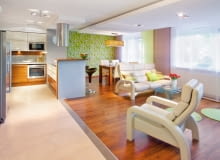 Konsekwentnie stosowane akcenty żywej zieleni sprawiają, że niezależnie od pory roku w tym mieszkaniu panuje niezwykle radosna, wiosenna atmosfera. <BR /> MIESZKANIE. Efektowna lampa wisząca rzuca światło przede wszystkim na stół. W części wypoczynkowej zainstalowano w suficie podwieszanym halogeny. Stół, tak jak wszystkie meble, jest fornirowany orzechem; z takiego drewna są również panele podłogowe.