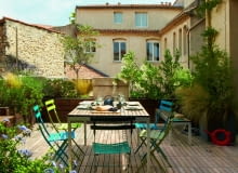 Rozległy taras wychodzi na patio. Krzesła Bistro (Fermob), drewniana zabudowa dla roślin i ławki to dzieło pana domu.