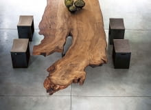 NUMER JEDEN. Blat tego niezwykłego stołu został zrobiony z ogromnego pnia kauri, najstarszego i najdroższego drewna na świecie, pochodzącego z Nowej Zelandii. Taki luksusowy mebel nie potrzebuje towarzystwa. Właściwie powinien stać samotnie w pustej przestrzeni, bo swoją urodą przyćmi wszystko. riva1920.it