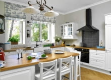 Rzymskie rolety z dekoracyjnej tkaniny dopasowano do stylu kuchni.