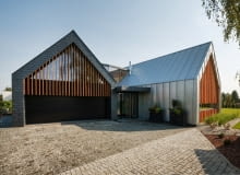 Kubatury budynków są zróżnicowane materiałowo. Północna część pokryta jest ciemnym, naturalnym łupkiem. Południowa - blachą Rheinzink w kolorze patyny, montowaną w podwójny rąbek stojący. Uzyskano w ten sposób ciekawy efekt estetyczny, ale i praktyczny. Wybór niezwykle trwałych materiałów elewacyjnych i rezygnacja z rynien sprawia, że dom przez całe swe istnienie zachowa swój pierwotny wygląd właściwie bez konieczności obsługi. dom w tychach, dom stodoła, dom w stodole, nowoczesny dom