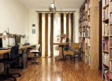 Dekoracja okna to jeden z elementów ocieplających to pomieszczenie. Dzięki lekko prześwitującym zasłonom do wnętrza wpada dzienne światło, ale słońce nie odbija się w monitorach. Na podłodze efektownie prezentuje się parkiet przemysłowy.