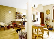 Wnętrze. Pokój dzienny od kuchni oddziela tylko półokrągła ścianka z oknem. Przy niej stoi drewniany stół, którego blat gospodyni pomalowała na dwa kolory - złoty i bordowy. Nad stołem wisi lampa z kloszem z żywicy, kupiona w niemieckiej galerii. UWAGA PONOWNA PUBLIKACJA ZA ZGODA WLASCICIELI