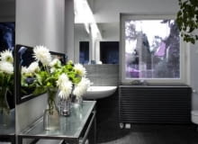 Spore okno, lustro, w którym odbija się wnętrze, oraz jednakowa okładzina na podłodze i na fragmentach ścian wywołują złudzenie większej przestrzeni. WNETRZA LAZIENKA