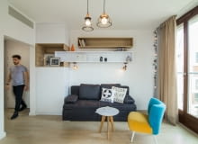 Kanapa rozkładana, musiała być dosyć prosta w formie, maksymalnie wygodna, no i musiała zmieścić się pomiędzy zabudową a oknem. W mebel słupek wkomponowano półki, które wprowadzają trochę rytmu i geometrii. Niewielki fotel i stolik utrzymane są w lekkiej stylistyce lat 50-60. Fotel w wyraźnej kolorystyce nadaje mieszkaniu barw i przewrotności. 30-metrowa kawalerka dla mężczyzny