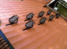 Stopnie kominiarskie umieszczone gęsto na dachu. Zapewniają bezpieczne dojście od okapu do widocznej w lewym rogu zdjęcia ławy kominiarskiej.