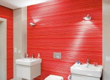 Zalety tapety. Nad umywalkami, osadzonymi na prostych szafkach, zainstalowano kinkiety o regulowanym kącie padania światła. Pomiędzy umywalkami zmieścił się podwieszony sedes. Łazienka, tapeta winylowa