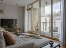 Salon otwierający się na loggię poprzez panoramiczne przeszklenie  to wymarzone miejsce  do przesiadywania i podpatrywania miejskich widoków.