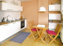 <B>Upiększyć, zmienić, udoskonalić... Właścicielka tej otwartej na salon kuchni cały czas zastanawiała się, co jeszcze można w niej zrobić, żeby było ładniej i wygodniej. To dążenie do perfekcjonizmu zaowocowało wnętrzem nowoczesnym i praktycznym. Zaaranżowano je minimalistycznie, a zarazem dekoracyjnie, co rzadko idzie w parze. Wprowadzono niewiele zmian funkcjonalnych (przede wszystkim nowy, wygodniejszy kącik jadalny), za to sporo estetycznych, które dodały wnętrzu indywidualnego charakteru. Warto zwrócić uwagę na ścianę nad ciągiem roboczym, którą oryginalnie ozdobiono przepisami na ulubione potrawy gospodyni.</B> <BR />TAK BYŁO. Wygodna, oszczędnie umeblowana kuchnia już się właścicielce znudziła. Szczególnie opatrzyła się jej kolorystyka, chciała też inaczej zaaranżować kącik jadalny. Miał być nie tylko praktyczny, ale i efektowny, bo właśnie w kuchni najczęściej przebywają goście.