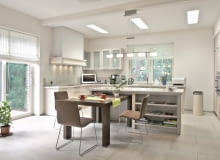 <B>Decyzja, gdzie postawić stół, powinna zależeć nie tylko od metrażu mieszkania i liczby pomieszczeń, ale także od stylu życia domowników. Wybierając miejsce na ten mebel, pamiętajmy o zachowaniu niezbędnych odległości: od ściany - ok. 80 cm, natomiast od regału albo komody - 100 cm. Na jedną osobę trzeba przeznaczyć ok. 60 cm długości blatu.</B> <BR >CENTRUM DOMOWE. Otwarta kuchnia i przestronny salon, a między nimi - aneks jadalny usytuowany przy wyspie. Rozwiązanie nie tylko wygodne, ale również sprzyjające zacieśnianiu więzów rodzinnych. <BR >Stół jest zrobiony z litego dębu zabejcowanego na brąz w szarawym odcieniu. Z jego masywną formą kontrastują lekkie krzesła na nóżkach-płozach wykonanych z cienkich stalowych rurek. <BR >Na co dzień część stołu jest wsunięta we wnękę w wyspie, dzięki czemu mebel zajmuje mniej miejsca.