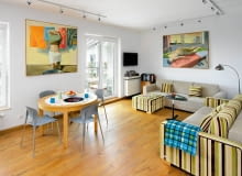 Otwarta część dzienna w tym mieszkaniu ma tak zwany układ wagonowy - w długim i wąskim pomieszczeniu zaaranżowano salon z jadalnią oraz kuchnię. z pewnością jest to wagon pierwszej klasy. <BR /> MIESZKANIE. Klimat części dziennej tworzą obrazy autorstwa Jana Szczepana Szczepkowskiego, przyjaciela gospodarzy. Justyna i Szymon przywieźli je z poprzedniego niewielkiego mieszkania, gdzie trudno było odpowiednio je wyeksponować. Teraz dzieła można podziwiać w pełnej krasie.