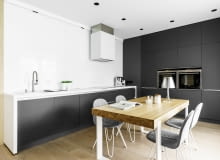 Pierwotnie deweloper w tym miejscu zaplanował salon. Projektantka przeniosła tu jednak kuchnię. Była to świetna decyzja. Całe mieszkanie na to tym bardzo zyskało. Nowoczesne mieszkanie w Gdyni z licznymi meblami w zabudowie