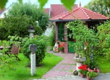 ścianki tej altany wyłożono klinkierowymi płytkami, dzięki czemu zyskała na elegancji. Gepflasterter Weg zum Gartenhaus, Rosa ( Rosen ), Pelargonium ( Geranien ) in Tpfen, Sitzplatz auf dem Rasen, getpferte KunstobjekteBezug : www.ton-art-jmp.de Tel.: 08752-168761039806, 61039807