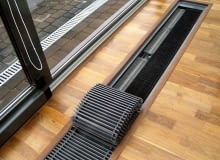 Jedynym śladem obecności grzejnika kanałowego w pomieszczeniu jest kratka przykrywająca specjalną wannę, w której jest on umieszczony. Do wyboru są kratki sztywne lub zwijane how.2~cX