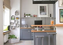 PO ZMIANIE. Wisząca półka nad półwyspem została zrobiona z metalowych rurek i blachy według projektu architektów. To element wyłącznie dekoracyjny - światło ustawionych tu świec tworzy wieczorem miły nastrój. kuchnia, metamorfoza kuchni, meble kuchenne