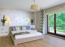 Dom miał być przytulny, urządzony z wyraźną przewagą naturalnych materiałów: drewna, wikliny i bawełny, ale też z nutą nowoczesności. Właścicielom, Monice i Adamowi, udało się spełnić to marzenie. <BR /> DOM. Sypialnia, podobnie jak cały dom, jest utrzymana w stonowanych brązach, beżach i bielach. Spokojny wystrój ożywiają kwiaty - zarówno te prawdziwe, jak i na tkaninach. Ścianę za łóżkiem wykończono tynkiem strukturalnym. Zabudowa z lakierowanego na biało drewna, pełniąca funkcję półki, kryje kable zasilające lampki.