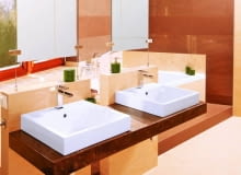 Łazienka 1. Wannę na podeście przesłaniają dwie ścianki podtrzymujące blat z umywalkami oraz lustra, które zamocowano na stalowych linkach rozpiętych pomiędzy ściankami a sufitem. W strefie kąpielowej przeważają brązowe płytki, w pozostałych - beżowe. Łazienka 1. Wannę na podeście przesłaniają dwie ścianki podtrzymujące blat z umywalkami oraz lustra, które zamocowano na stalowych linkach rozpiętych pomiędzy ściankami a sufitem. W strefie kąpielowej przeważają brązowe płytki, w pozostałych - beżowe.