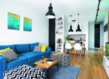 POKÓJ DZIENNY, otwarty na kuchnię i przedpokój, wygląda na przestronniejszy, niż jest w rzeczywistości. Stoją tu tylko kanapa z pufami (Rafek Meble), stolik kawowy (Take me Home) oraz niewielki regał i szafka RTV (zrobione na wymiar przez stolarza). Oszczędny wystrój urozmaicają plamy kolorów, wyraziste wzory i obrazy namalowane przez siostrę gospodarza.