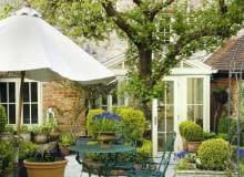 Wystarczy pojedyncze drzewo i kilka roślin w pojemnikach, żeby pośród ciasnej zabudowy powstał piękny ogródek. W dodatku jest łatwy w utrzymaniu projektowanie ogrodów