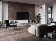 Podłoga FertigDeska Chevron Dąb Color Vento o wzorze jodły francuskiej, która świetnie komponuje się z industrialnymi akcentami matowej czerni i eleganckim kamieniem. Podłoga FertigDeska Chevron Dąb Color Vento o wzorze jodły francuskiej, która świetnie komponuje się z industrialnymi akcentami matowej czerni i eleganckim kamieniem.