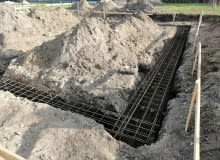 Zmiana posadowienia. Ze względu na zaleganie warstwy nośnej poniżej strefy przemarzania zdecydowano się wykonać ławy o wyższym niż założono w projekcie przekroju posadowienie fundamenty budowa domu posadowienie budynku posadowienie fundamentów