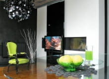 <b> MINIMALIZM Z DUSZĄ. Chłodna nowoczesność ocieplona starannie dobranymi drobiazgami utrzymywanymi w starym stylu. Czarno-biała kolorystyka ożywiona energetycznymi zielonymi dodatkami. Projektanci wykazali się konsekwencją naprawdę godną pochwały. </b> <BR /> Telewizor jest zainstalowany na ruchomym szklanym panelu, którego kąt można ustawiać w zależności od potrzeby. Można też zasłonić nim drzwiczki kominka. OLYMPUS DIGITAL CAMERA