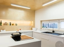 Podświetlana wnęka w kuchni jest ważnym elementem dekoracyjnym w kuchni. Kuchnia jest jedynym pomieszczeniem, w którym sklejka jest nie tylko na ścianie, ale także na suficie. Mieszkanie całe w sklejce