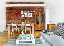 DO STAREJ KAMIENICY pasują meble z historią - wyszukana w gliwickim sklepie z antykami witryna z zachowanymi kryształowymi przeszkleniami oraz wiekowa szafka nocna (dla przekory ustawiona w salonie). Ceglana ściana to doskonałe miejsce na galerię rodzinnych zdjęć. Oświetlają ją halogeny wbudowane w panel z płyty gipsowo-kartonowej.