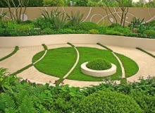 Pomiędzy betonowymi kostkami 'namalowano' zielone pasy z trawy. Natomiast na murawie - białe łuki z kostki. Przy takim rozwiązaniu trzeba wybrać nasiona traw odpornych na deptanie, a skrawki murawy - regularnie podlewać i kosić.