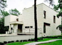 Elewacja domu. Płaski dach i prostopadłościenne bryły obłożone płytami piaskowca nadają współczesnej rezydencji oryginalny charakter