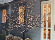 Drzewko LED - aż 160 diod umieszczonych w kwiatkach z tworzywa sztucznego. Konstrukcja z drutu owiniętego tasiemką. W zestawie jest zasilacz sieciowy, adapter i szpice do wbicia w ziemię. Wysokość ok. 167 cm. Cena 259,95 zł, Tchibo świąteczne dekoracje, święta, oświetlenie