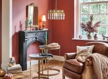 Dekoracyjne oświetlenie, ciepły pled, dodatki w ciepłych barwach – wszystko to wprowadza jesienny klimat do salonu.