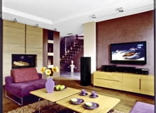 Duży ekran telewizora dobrze wygląda na fioletowej ścianie pomalowanej techniką przecierek. Do jej barwy dobrano kolor obicia mebli wypoczynkowych. UWAGA PONOWNA PUBLIKACJA ZA ZGODA WLASCICIELI