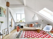 W pokoju dziennym gołębie szarości i pudrowe róże przełamano mocnymi graficznymi wzorami, m.in. na dywanie Catania (proj. Sandra Figuerola). Fotel z NRD idealnie pasuje do współczesnej lampy podłogowej Grasshopper i do kanapy. Oryginalny stolik kawowy to efekt inwencji Anny. - Pojechałam na szrot i poprosiłam o kawałek starej zardzewiałej rury - opowiada. - Na niej położyłam zamówiony marmurowy blat. I gotowe!