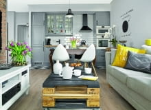 Europalety na salonach - stolik kawowy to dzieło Tomka, który po godzinach lubi poszaleć z młotkiem i wiertarką. Szafkę pod telewizor właściciele kupili w meblarnia.com.pl, kanapę w sklepie Inne Meble (stąd jest też zastawa).