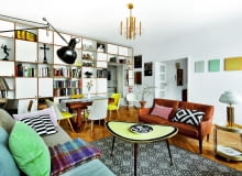 Ściana oddzielająca salon od przedpokoju zabudowana jest regałem ze sklejki (Intterno Home). Na półkach m.in. renesansowy krucyfiks i kolekcja bauhausowskich dzbanków. Pozostałe meble to vintage, w większości z lat 60. regały na książki