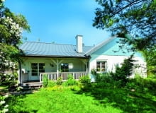 Parterowy murowany dom otynkowano na biało i ozdobiono detalami z drewna, co nadało całości malowniczy charakter wiejskiego siedliska dom jednorodzinny, dom parterowy, dom z udogodnieniami dla niepełnosprawnych