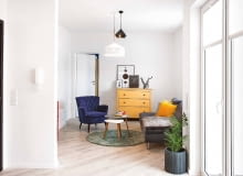 Z ZASKOCZENIA: ten widok pokoju dziennego nie zapowiada jeszcze feerii kolorów. Chyba że zajrzymy za ściankę, na której wisi domofon (po drugiej stronie stoi czerwona szafka). Albo uchylimy drzwi do sypialni pomalowanej na kobaltowy kolor.