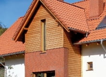 Przed zamontowaniem desek oblicówki, na styku elewacji klinkierowej i drewnianej należy zamontować listwę okapową, chroniącą przed zaciekaniem wody pod ocieplenie ze styropianu - może to być okapnik z blachy powlekanej lub pasek papy wywinięty na dekoracyjną deskę okapową.