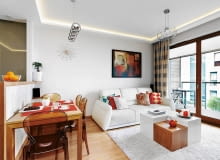 <B>Projektując mieszkanie Anny i Janusza, dużą wagę przyłożono do oświetlenia. Wnętrza są nie tylko jasne. Światło modeluje też przestrzeń, wyodrębnia z niej strefy o różnej funkcji, a nawet wizualnie poprawia niekorzystny kształt pomieszczeń.</B> <BR />Salon połączony z kuchnią, choć długi i wąski, wcale na taki nie wygląda. To dlatego, że umiejętnie ustawiono meble, np. spory stół prostopadle do długiej ściany, natomiast stolik kawowy - centralnie. W ten sposób wizualnie skrócono pomieszczenie. Taśmy LED, zainstalowane za gzymsami pod sufitem, dodatkowo optycznie poprawiają kształt wnętrza i&#8200;podkreślają część wypoczynkową.