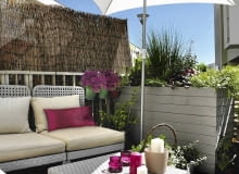 Kącik do relaksu - od strony chodnika przed wzrokiem przechodniów chroni mata i wysoka skrzynia dla roślin. W upały cień zapewnia jasny parasol.