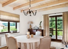 <B>Wnętrze zostało urządzone w rustykalnym stylu, dlatego pani domu udekorowała okna prosto drapowanymi zasłonami z lnianego płótna. Aranżacja jest równie naturalna i piękna jak Puszcza Knyszyńska widoczna na horyzoncie.</B> <BR />Długie zasłony w drzwiach balkonowych i rolety w oknie uszyto z grubego, gęsto tkanego lnu. Pani domu tak podoba się ten rodzaj tkaniny, że wybrała ją także na obicia krzeseł, obrus oraz abażur lampy.