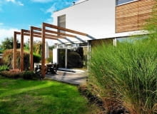 Konstrukcja pergoli podkreśla podział przestrzeni tarasu na dwie strefy: zadaszoną jadalnię i słoneczną plażę. Konstrukcja pergoli podkreśla podział przestrzeni tarasu na dwie strefy: zadaszoną jadalnię i słoneczną plażę.