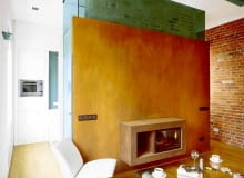 Ściana z kominkiem na pierwszy rzut oka wygląda tak, jakby była zrobiona z bardzo starego drewna. Dopiero gdy się jej dotknie, można się przekonać, że to nie drewno, ale spatynowana stal (autorski pomysł i wykonanie Michała Urbana). UWAGA PONOWNA PUBLIKACJA ZA ZGODA WLASCICIELI