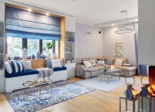 W salonie zwracają uwagę dodatki - chińskie wazy, poduchy w paski i marokańską koniczynkę, wzorzysty dywan (z Mint Grey i Raw Decor). Do tapety z motywem kwitnących gałązek wiśni idealnie pasuje obraz Ivy Białopiotrowicz, na którym rozsiadło się żółte ptasie stadko. Kominek, poprzednio zainstalowany pośrodku salonu, został zamieniony na model narożny, tak by był widoczny zarówno z salonu, jak i jadalni. Światło i wzór: spójrzmy czasem w górę. Ciekawa lampa sufitowa potrafi naprawdę przykuć wzrok. Dla całej rodziny bardzo ważne jest wspólne spędzanie czasu. Stąd pomysł na dodatkowe wygodne siedzisko w salonie. Umieszczono je we wnęce - do jej zbudowania wystarczyły dwie wysokie szafki po bokach okna i rama z płyty gipsowo-kartonowej. Zainstalowano w niej oświetlenie. Złote stoliki kawowe są z Zara Home. W salonie zwracają uwagę dodatki - chińskie wazy, poduchy w paski i marokańską koniczynkę, wzorzysty dywan (z Mint Grey i Raw Decor). Do tapety z motywem kwitnących gałązek wiśni idealnie pasuje obraz Ivy Białopiotrowicz, na którym rozsiadło się żółte ptasie stadko. Kominek, poprzednio zainstalowany pośrodku salonu, został zamieniony na model narożny, tak by był widoczny zarówno z salonu, jak i jadalni. Światło i wzór: spójrzmy czasem w górę. Ciekawa lampa sufitowa potrafi naprawdę przykuć wzrok. Dla całej rodziny bardzo ważne jest wspólne spędzanie czasu. Stąd pomysł na dodatkowe wygodne siedzisko w salonie. Umieszczono je we wnęce - do jej zbudowania wystarczyły dwie wysokie szafki po bokach okna i rama z płyty gipsowo-kartonowej. Zainstalowano w niej oświetlenie. Złote stoliki kawowe są z Zara Home.