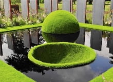 Trawnik jak zielona wyspa. Półkula i misa to aranżacja tylko na pokaz, ponieważ trudno utrzymać ją w takim stanie przez dłuższy czas. Była atrakcją brytyjskiej wystawy Hampton Court Palace Flower Show w 2011 roku