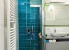 ŁAZIENKA. Kolorystyka wnętrza miała się kojarzyć z wypoczynkiem nad wodą. I tak właśnie jest dzięki zestawieniu dwóch barw - błękitu i bieli. Pas mozaiki w morskich odcieniach prowadzi od drzwi wejściowych wprost do kabiny prysznicowej. Na pozostałej części podłogi ułożono deski z drewna teku, które jest odporne na działanie wody (dodatkowo zostało zaolejowane). ŁAZIENKA. Kolorystyka wnętrza miała się kojarzyć z wypoczynkiem nad wodą. I tak właśnie jest dzięki zestawieniu dwóch barw - błękitu i bieli. Pas mozaiki w morskich odcieniach prowadzi od drzwi wejściowych wprost do kabiny prysznicowej. Na pozostałej części podłogi ułożono deski z drewna teku, które jest odporne na działanie wody (dodatkowo zostało zaolejowane).