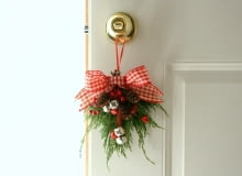 Już prosty stroik wykonany własnoręcznie i zawieszony na klamce nada drzwiom świątecznego charakteru. drzwi, Boże Narodzenie, dekoracje świąteczne