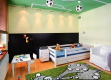 <B>Zamiast kupować kolejną zabawkę, dającą radość na dwa dni, podarujmy dziecku nowy wystrój jego pokoju. Taki, który stworzy maluchowi nie tylko wspaniałe warunki do zabawy, ale i możliwość rozwoju zainteresowań oraz wyrobi w nim poczucie estetyki. Choćby taki jak ten.</B> <BR />Największą atrakcją pokoju jest bez wątpienia boisko piłkarskie namalowane na suficie. Boisko, a zarazem cały pokój, oświetlają lampy-piłki i halogenowe lampki rozpięte na podwójnych linkach.