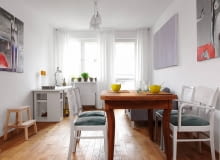 Meble jadalniane z pchlego targu gospodyni własnoręcznie odnowiła. Dębowy stół po zeszlifowaniu starego lakieru zaolejowała, a bukowe krzesła z oparciami z rafii pokryła białą lakierobejcą, zmieniła też ich tapicerkę. salon z jadalnią, meble z odzysku